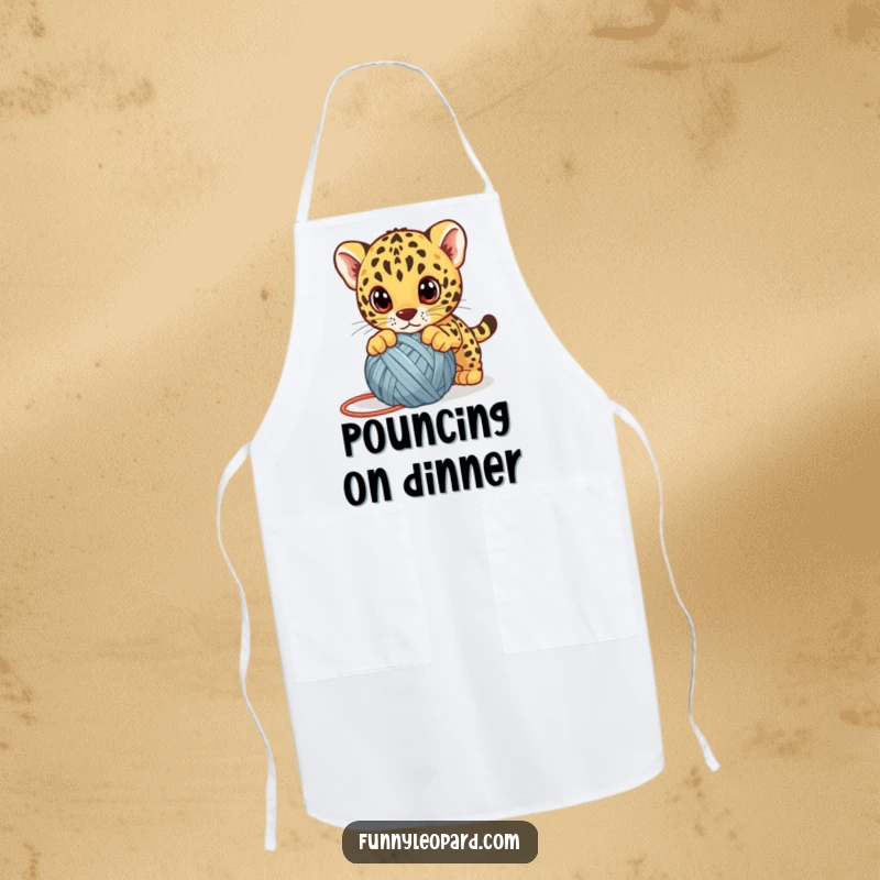 Funny leopard cub apron, a cute kitten playfully pouncing on a yarn ball with big eyes, humorous and adorable kitchen essential.