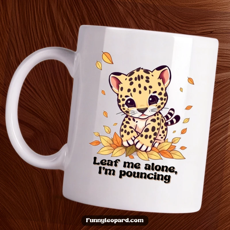 Funny mug with a cute leopard cub joyfully pouncing on colorful autumn leaves, embodying playful energy and seasonal fun.