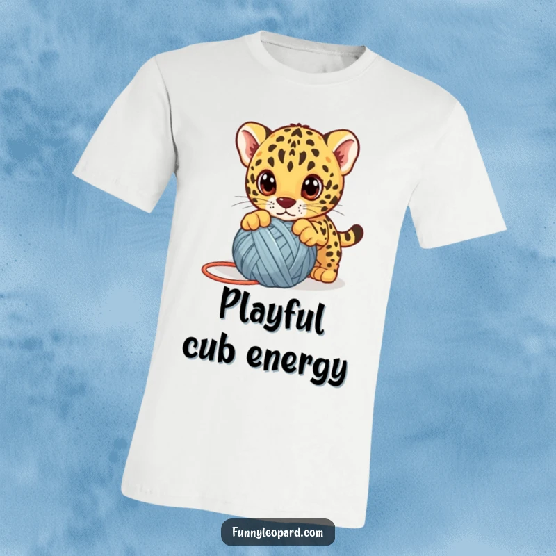 Funny leopard cub t-shirt, a cute kitten playfully pouncing on a yarn ball with big eyes, designed for animal humor.